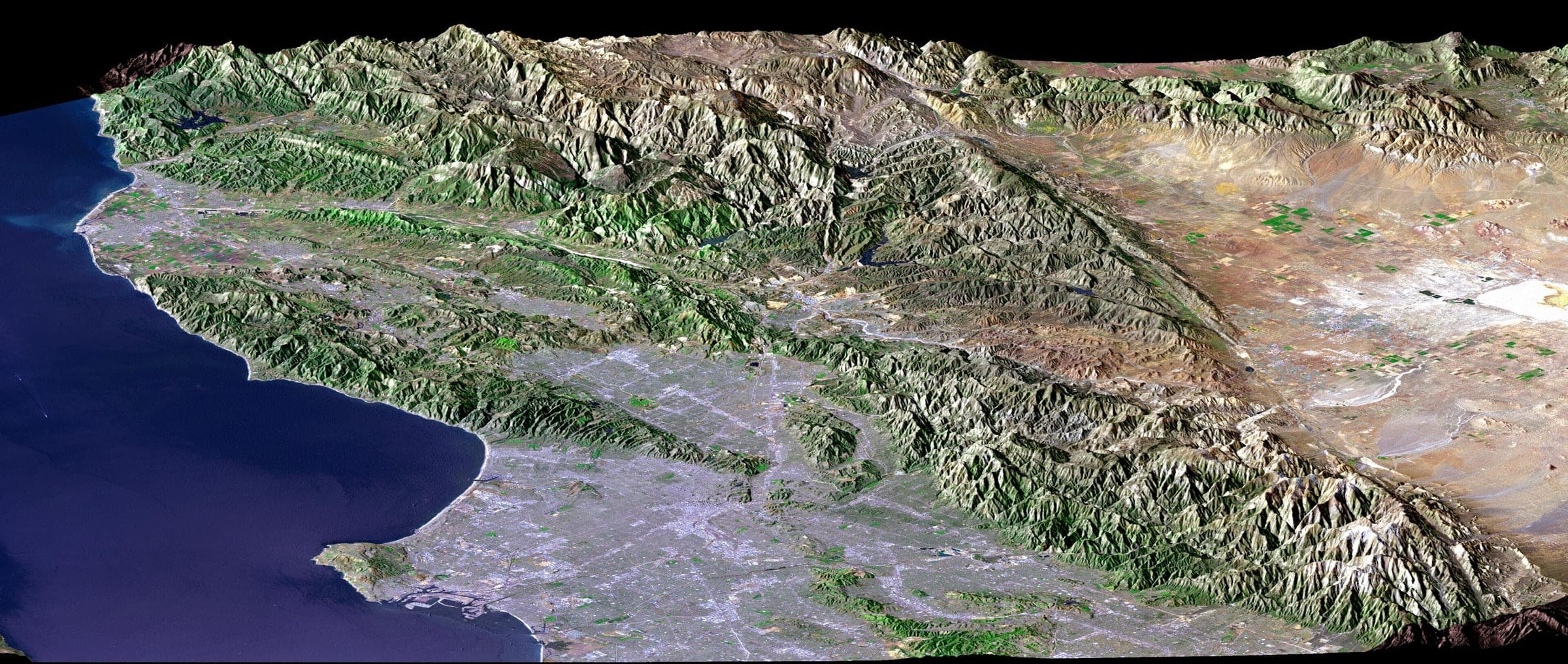 The Los Angeles basin from 705 kilometres up, the street grid running unbroken from the Santa Monica Mountains down to the Pacific. Landsat frame, 30 metres per pixel.